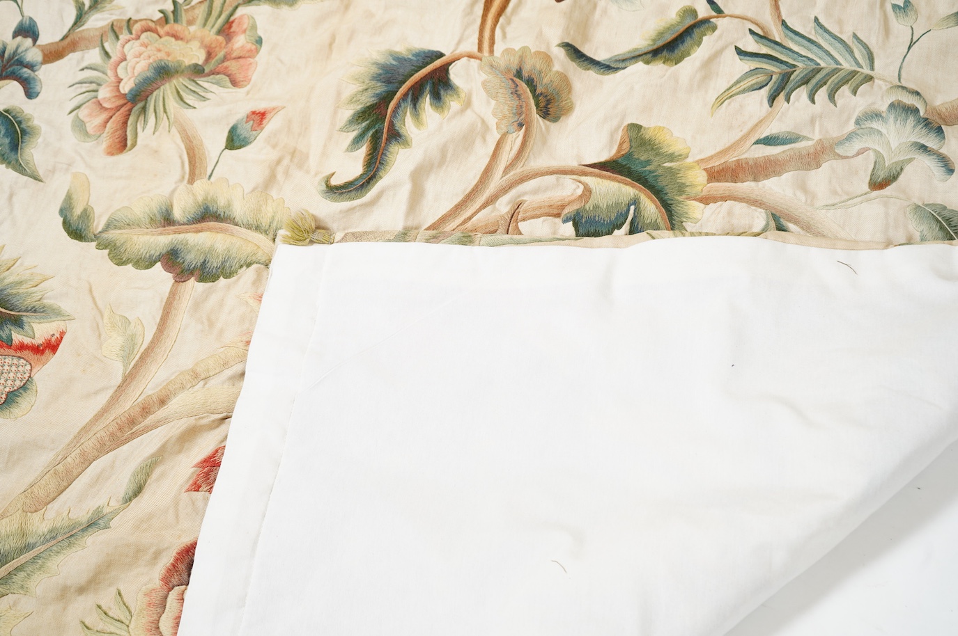 Six 20th century crewel work ‘Tree of Life’ cream linen curtains. Worked at the base in coloured wools depicting a pastoral scene of a shepherd playing a flute amongst sheep, deer, squirrels and flowers with a dog chasin